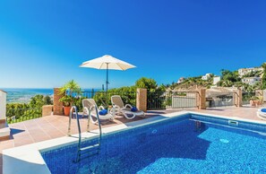 Een buitenzwembad, een verwarmd zwembad en ligstoelen