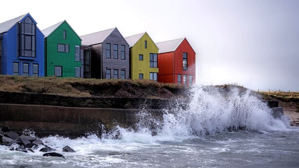 Een rij kleurrijke huizen aan zee.