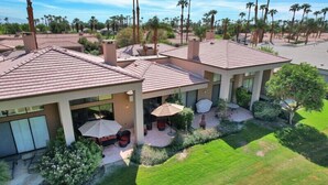 A residential property with a patio area, outdoor furniture, and a well-maintained lawn. - Fabulously Remodeled 2 Bedroom Condo With Beautiful Golf and Mountain Views (La Quinta)