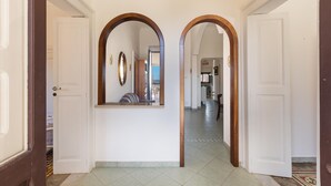 A hallway with white walls, two wooden-framed arches, and a tiled floor. - 2696 Appartamento La Nave by Barbarhouse (Racale)