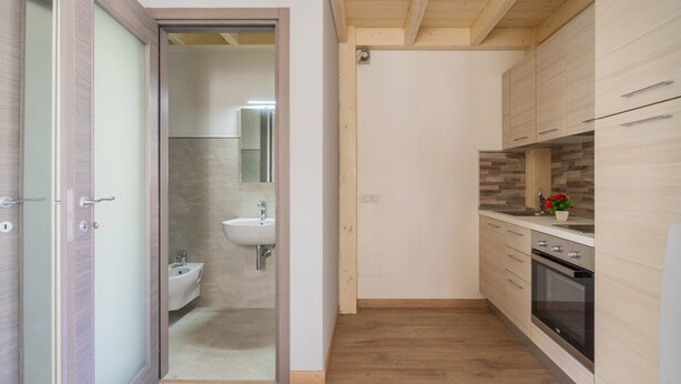 Een moderne keuken met houten kastjes, een ingebouwde oven en een spoelbak.