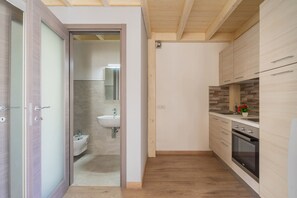 Una cocina moderna con armarios de madera, horno empotrado y un lavamanos.