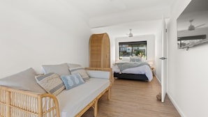 A bedroom with a bed, a sofa, a wardrobe, and a window with a view. - Bella Vita by Experience Jervis Bay (Vincentia)