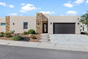 A modern two-story house with a stone facade, a garage, and a landscaped front yard. - Azure Abode: Large Groups + Private Pool + Roof Top Deck (Hurricane)