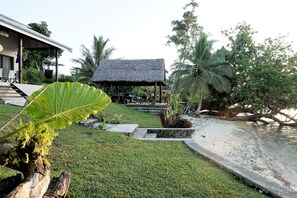 Ein Resort mit einem strohgedeckten Gebäude, einem Pool und üppiger Vegetation.