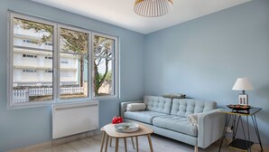 Ein modernes Wohnzimmer mit grauem Sofa, einem kleinen Holztisch und einer Lampe.