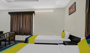 Une chambre d’hôtel avec deux lits, un bureau et une chaise.