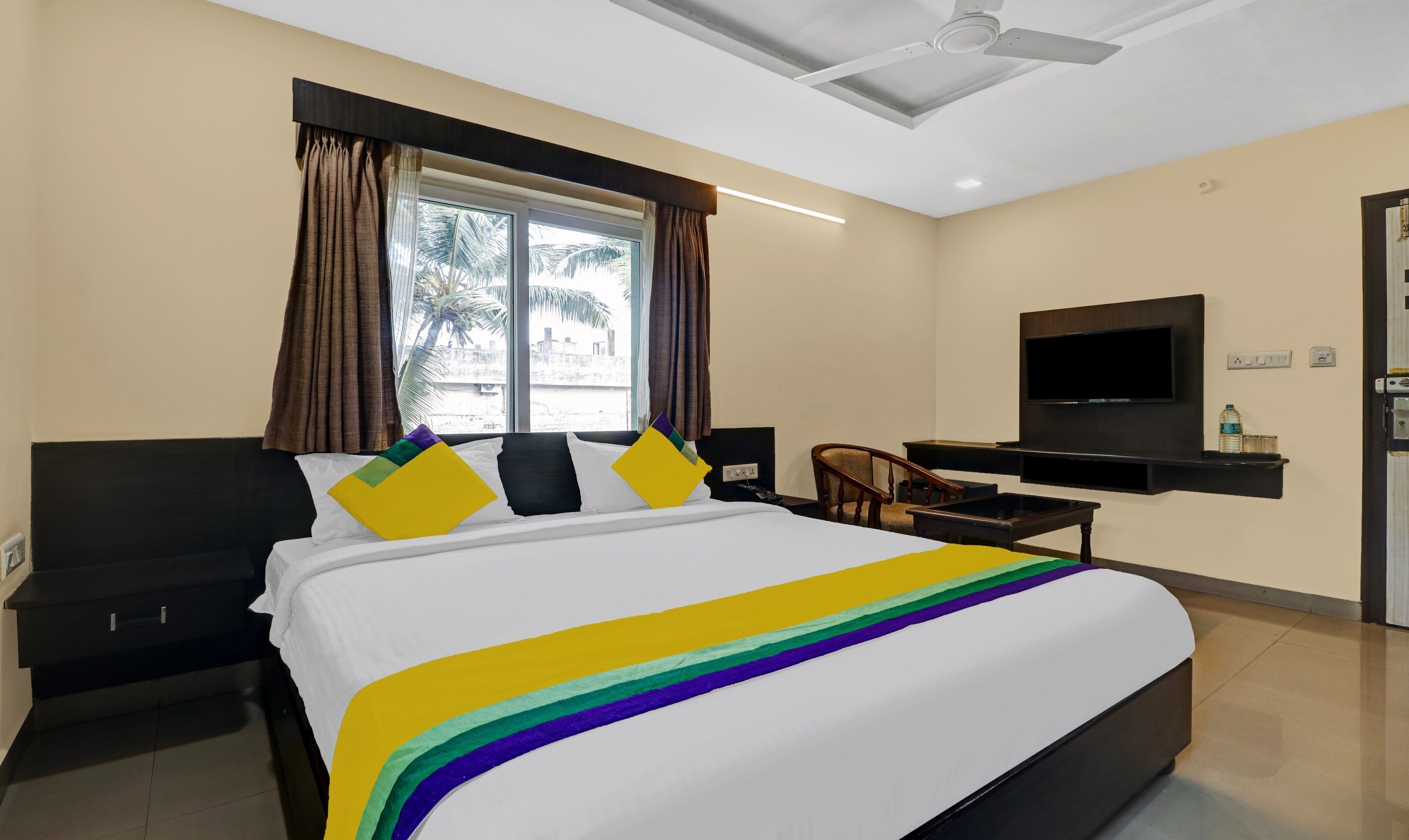 Una habitación de hotel con cama, televisión, escritorio y silla.