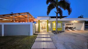 Uma casa moderna com varanda coberta, garagem e entrada bem iluminada.