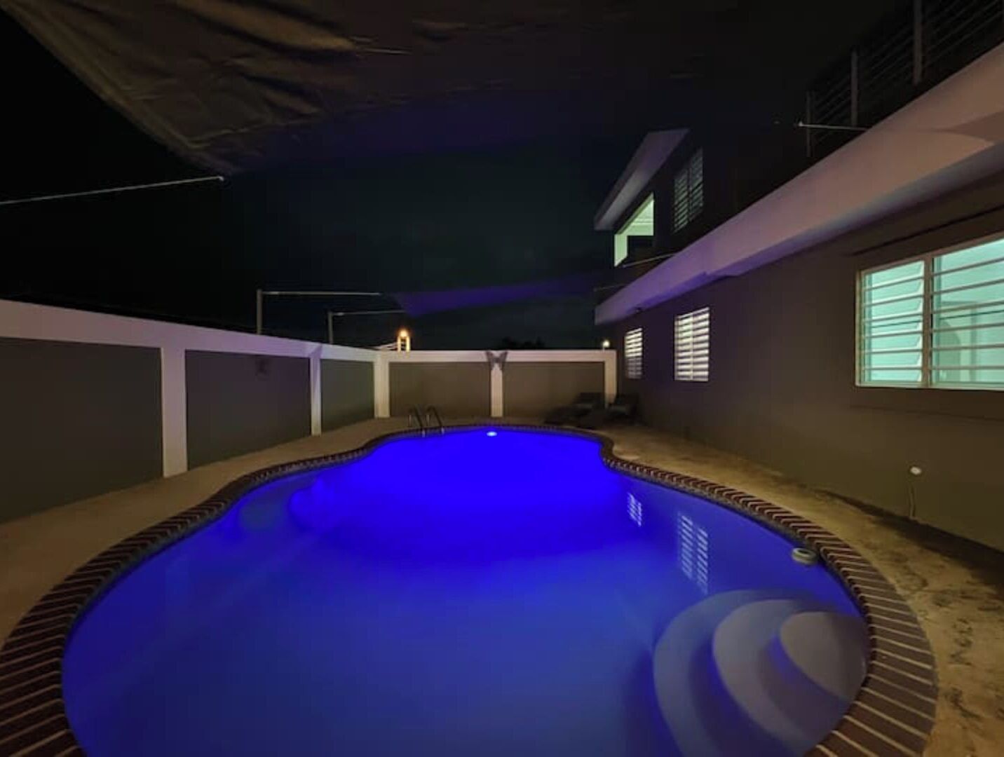A swimming pool at night with a blue light.