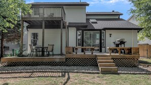 A two-story house with a covered patio, a barbecue area, and a small deck. - Spacious, 3 bedroom home, finished basement on quiet court (St. Peters)