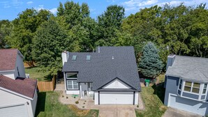 A two-story house with a garage, a front yard, and a driveway. - Spacious, 3 bedroom home, finished basement on quiet court (St. Peters)