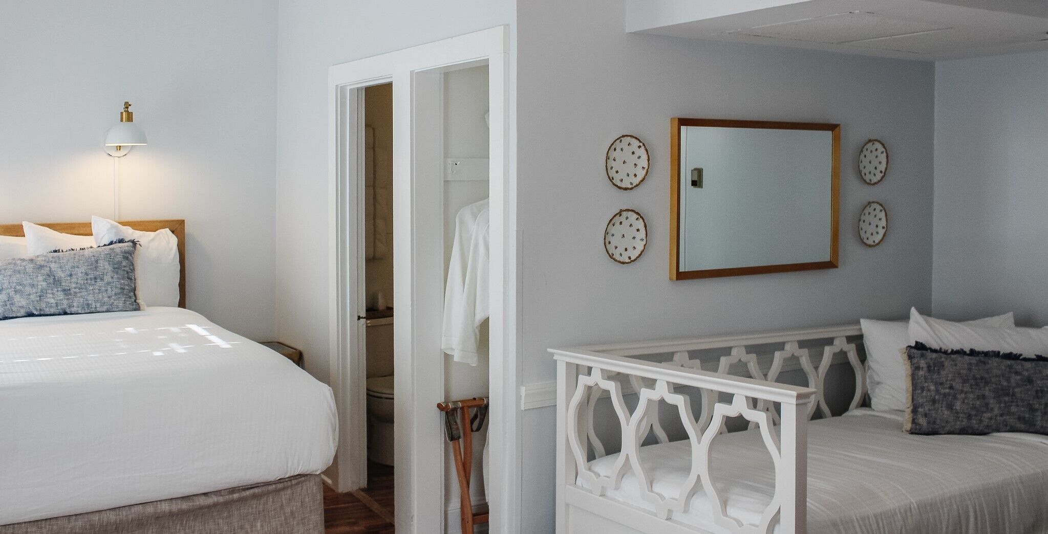 Une chambre à coucher avec un lit, une table de chevet, une armoire et un miroir au mur.