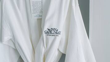 Una bata blanca colgada en un perchero con una etiqueta que dice "Inn at Cape May Established 1894".