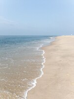 On the beach, white sand, sun loungers, beach umbrellas