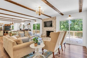 A spacious living room with a fireplace, a dining area, and a kitchen in the background. - Waterfront Retreat w/ Private Dock, Kayaks, Deep Water, Gameroom, Sleeps 12 (Clarksville)