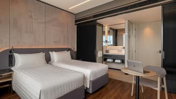 Ein modernes Hotelzimmer mit einem großen Bett, einem Schreibtisch mit einem Laptop und einer kleinen Sitzecke.