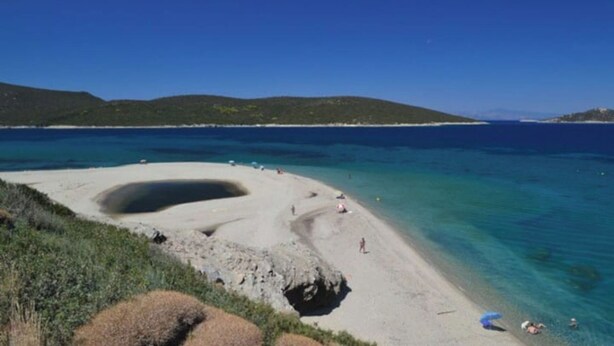A beach with clear turquoise water, a sandy shore, and a rocky outcrop. - Sea View flat - Marmari village 1hour from Rafina (marmari)