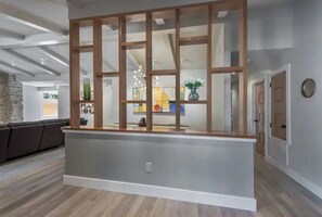 Welcome to a contemporary reception area with a comfortable seating space and a stylish counter.
