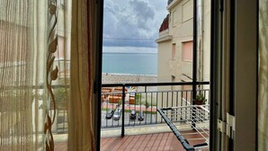 Un balcón con vista al mar y un estacionamiento.