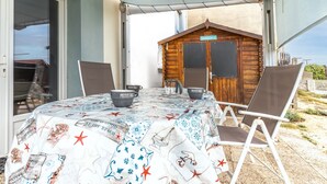 An outdoor dining area with a table set for two, two chairs, and two bowls on the table. - Apartment with Private Terrace & Shared Garden (Mimizan)
