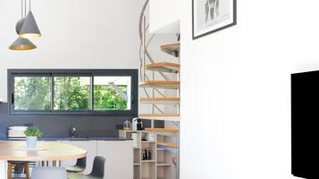 Una cocina moderna con ventana, estanterías empotradas y un comedor con sillas.