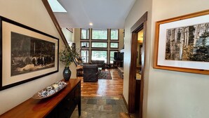 A hallway with a wooden console table, a vase with greenery, and framed artwork on the walls. - The Great Escape at Heavens Gate A/C, fire pit, The Great Escape at Heavens Gate (McCall)