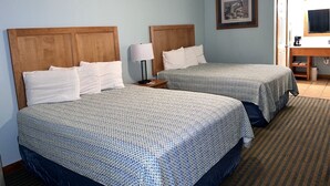 Une chambre d’hôtel avec deux lits, un bureau et une chaise.