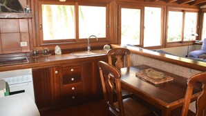 Une cuisine en bois équipée d’un évier, d’une cuisinière et d’une table à manger avec des chaises.