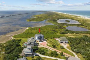 A coastal property with multiple houses, a dock, and a beach. - Premier Soundfront Dog Friendly w/ Pool, Hot Tub, Windsurfing Access, Theater (Rodanthe)