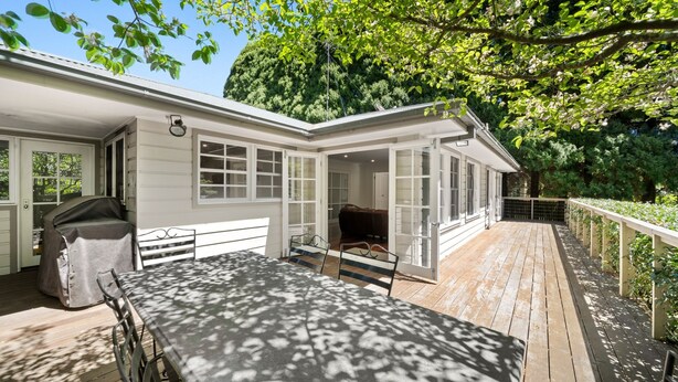 A covered patio with a table and chairs, a barbecue grill, and a view of a forested area. - Clanalpine Retreat  Leura (Leura)