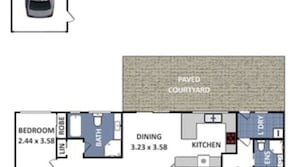 A floor plan of a hotel room with a bedroom, bathroom, dining area, kitchen, and a paved courtyard.