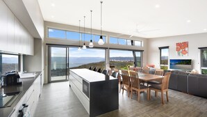 Une cuisine moderne dotée d’un grand îlot central, d’un coin repas et offrant une vue sur les montagnes.