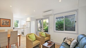 Relax in a bright and inviting living area with a sofa, armchairs, and dining table.