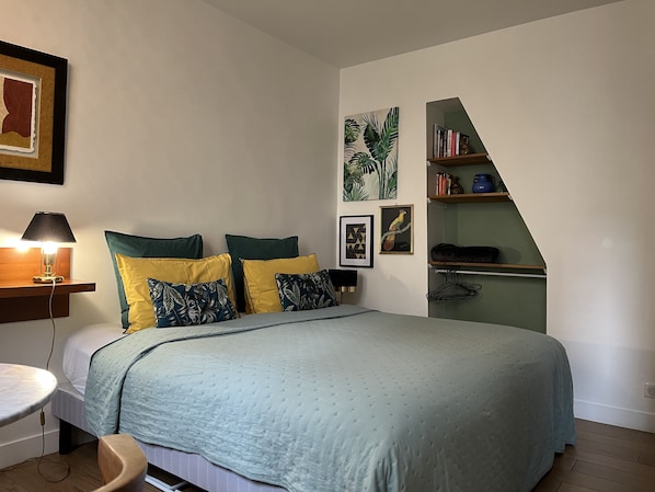 A bedroom with a bed, bedside tables, a desk, and a bookshelf.