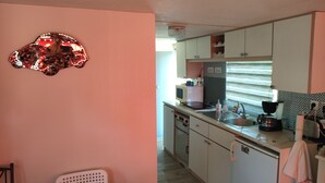 A kitchen with white cabinets, a microwave, and a sink.