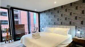 Una camera da letto moderna con un letto grande, una parete decorata e vista sull'esterno.