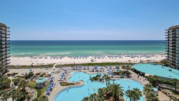 Un resort con una piscina grande, playa y vista al océano.
