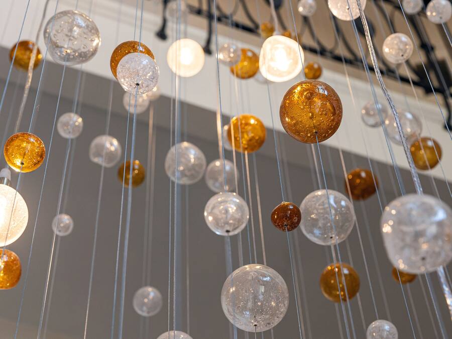 A ceiling with multiple spherical light fixtures of varying sizes and colors.