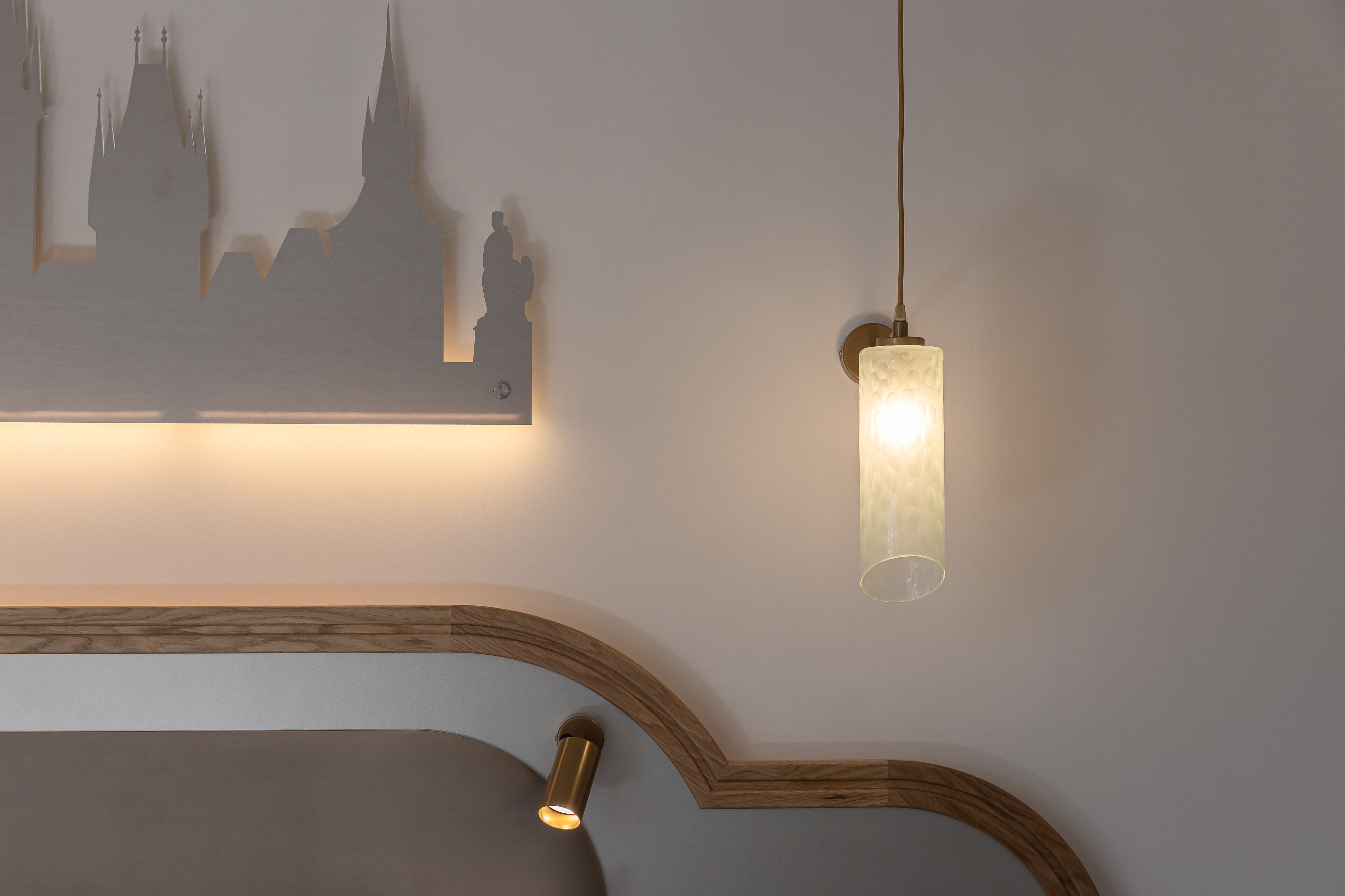 A wall-mounted light fixture with a clear glass shade and a simple, modern design.