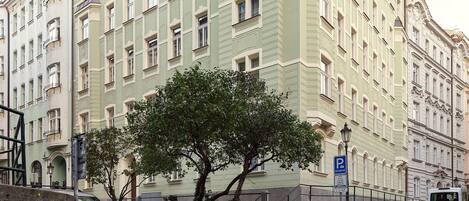 A historic building with a classic architectural style, featuring multiple windows and a prominent corner tower.