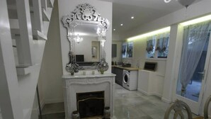 A modern kitchen with a built-in washing machine, a fireplace, and a large ornate mirror above it. - Haut Marais, rue Volta, 2 bedrooms, 2 bathrooms (Paris)