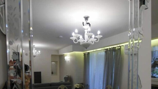 A dining area with a large mirror, chandelier, and a dining table with chairs. - Haut Marais, rue Volta, 2 bedrooms, 2 bathrooms (Paris)