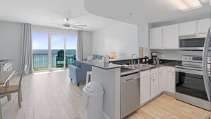 Una cucina moderna con isola centrale, zona pranzo con vista e balcone panoramico.