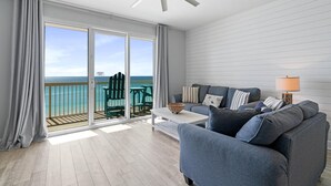 Un soggiorno moderno con un divano grigio, un tavolino da caffè bianco e una ventola a soffitto.