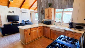 A compact kitchen with wooden cabinets, a stove, and a microwave.