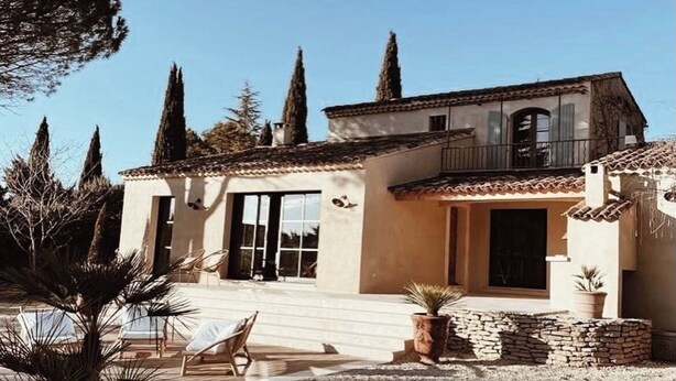 A two-story house with a balcony, a patio with lounge chairs, and a stone wall. - Maison ELA à lourmarin (Lourmarin)