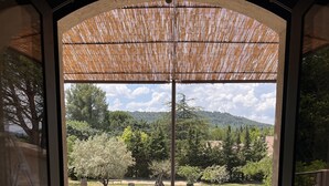 A wooden deck with two white lounge chairs and a pool. - Maison ELA à lourmarin (Lourmarin)