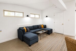 A modern living room with a sectional sofa, a coffee table, and a door.