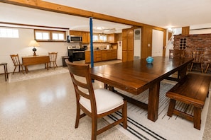 A spacious kitchen with wooden cabinets, a dining table, and chairs. - Large home w/huge yard, steps from the lake (Lexington)